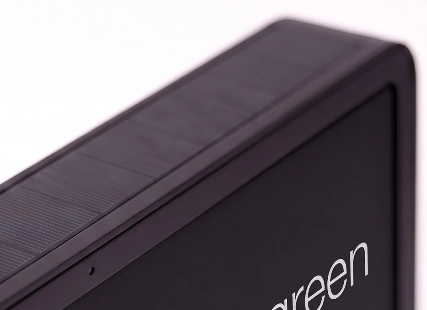 Close view of the sign's top edge: a full-length solar strip inset flush along the frame above the e-paper face.